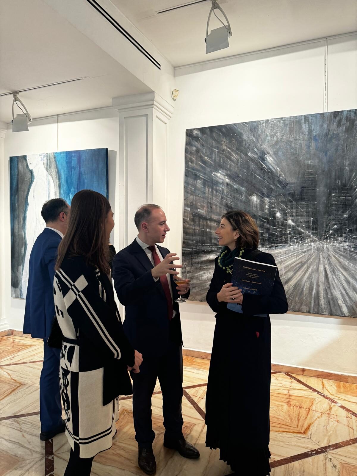 Marco Cioffi, founder di Neuram, in conversazione con i partecipanti a una galleria d'arte durante un evento culturale europeo.