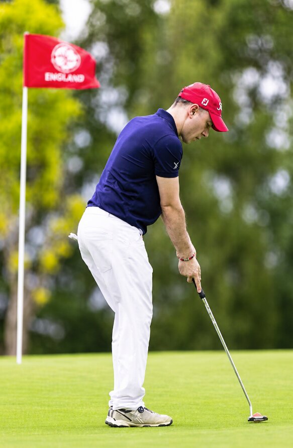 Marco Cioffi gioca a golf, concentrato prima di eseguire un putt sul green.