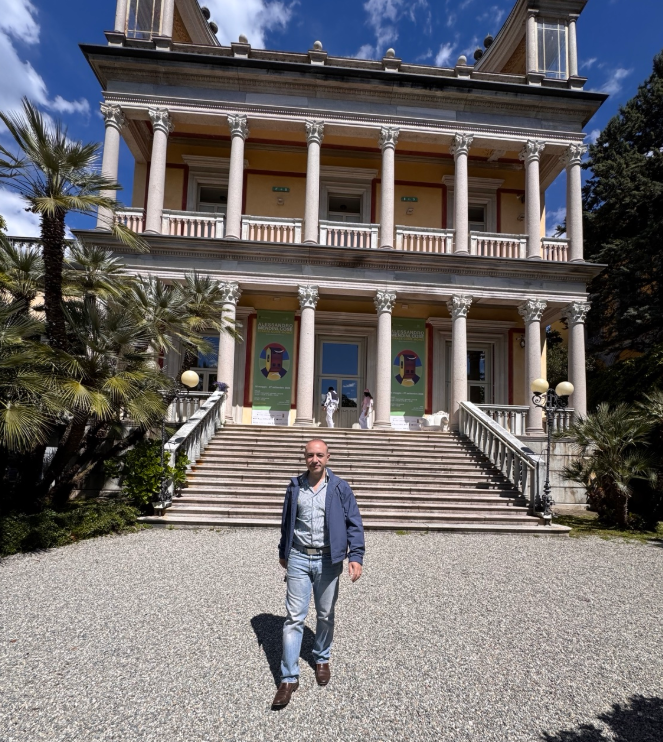 Marco Cioffi davanti alla scalinata neoclassica di Villa Giulia a Verbania, sul Lago Maggiore, tra palme e colonne corinzie.